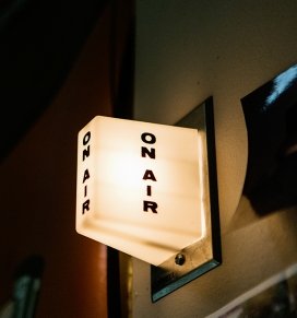 Image of the On Air sign lit up outside the radio station