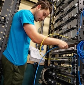 A student works on networking in an Information Technology class