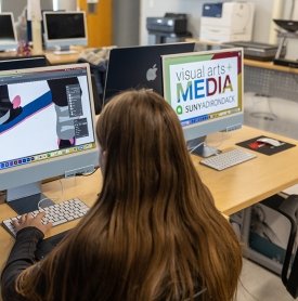 Student working on a MAC computer in Adobe Illustrator