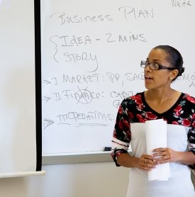 Female student speaking in front of class about a business plan