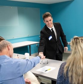 Business student shaking hands after his presentation