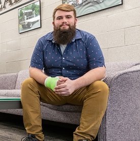 SUNY Adirondack alumni Tyler Coons sits in the offices of Tymetal