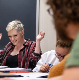 A student in a Creative Writing class cheers during a  discussion