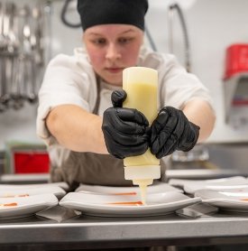 A culinary student plates cuisine