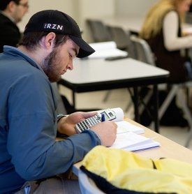 A student uses a calculator to solve a problem during math class