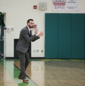 SUNY Adirondack men's basketball coach Maxx Sweet, a SUNY Adirondack alum, cheers his team on from the sidelines