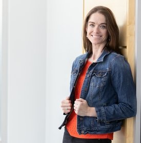 Image of Amy Ryan in a jean jacket leaning against a wall