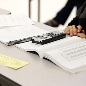 Image of a calculator and a finance textbook