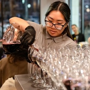 Female hospitality student pouring wine