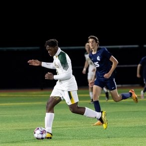 SUNY Adirondack student dribbles a ball during a soccer game