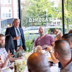 Group of people seated at a table at Seasoned laughing