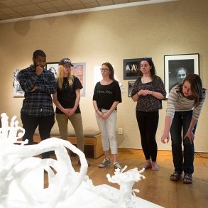 Students critiquing work in the visual arts gallery