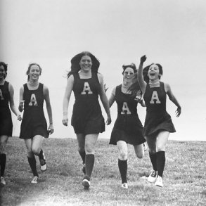 Photo from early college yearbooks of cheerleaders walking across a grassy knoll