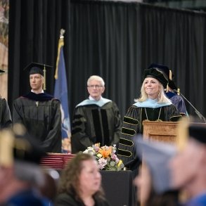 President Kristine D. Duffy and members of the Board of Trustees watch graduates file into Cool Insuring Arena for Commencement 2024