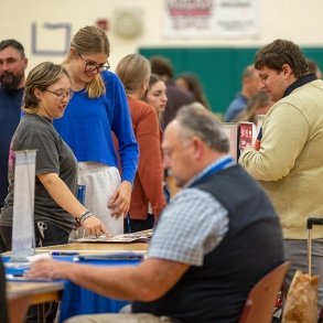 Two young adults smile as they review a presenter at a 2024 Job Fair on SUNY Adirondack's Queensbury campus.