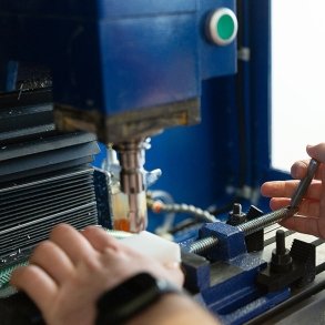 Close-up image of a student's hands working on an advanced manufacturing project