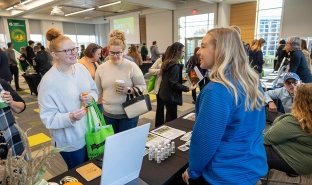 Kim Comisky, director of Healthcare Pathways at SUNY Adirondack, discusses program offerings with attendees at a college Open House event.