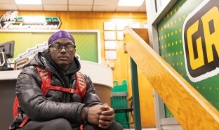 Student Xavier Baker is seen sitting on the steps in the Gymnasium. Baker is a basketball player, golfer and EOP student.