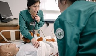 Two female nursing students working in the simulation lab