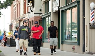 Three young men walk down Glen Street in downtown Glens Falls