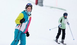 A student smiles as she skis down West Mountain in an Outdoor Education course