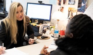 Professor of Business Kelli Hatin advises a student in her office