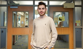 Parker Kaliesz stands in the Library in Scoville Learning Center