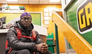 Student Xavier Baker is seen sitting on the steps in the Gymnasium. Baker is a basketball player, golfer and EOP student.