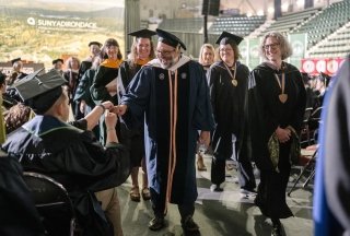 Faculty processing out of graduation congratulating recent graduates
