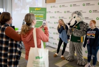 Prospective students pose for photos during an open house event at the college.