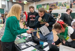 High school students receive information from a booth at a SUNY Adirondack college fair on campus