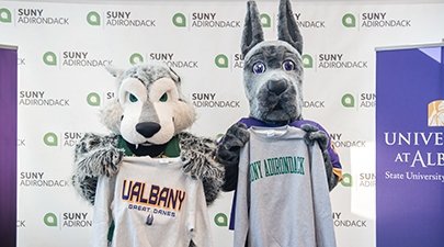 SUNY Adirondack mascot Eddy Rondack poses with University at Albany mascot Dane after the colleges' leaders signed a dual acceptance agreement