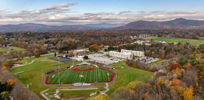 Aerial image of the Queensbury campus with the turf field as the main focus and mountains in the distance