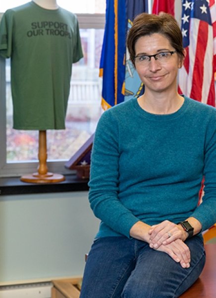 SUNY Adirondack alumna and U.S.Army veteran Anne Wojtowesc leans against a desk in the Veterans Center on campus