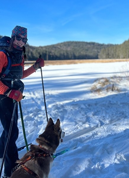 SUNY Adirondack Outdoor Education alumna Katelyn Kuklinski cross-country skis with her dog