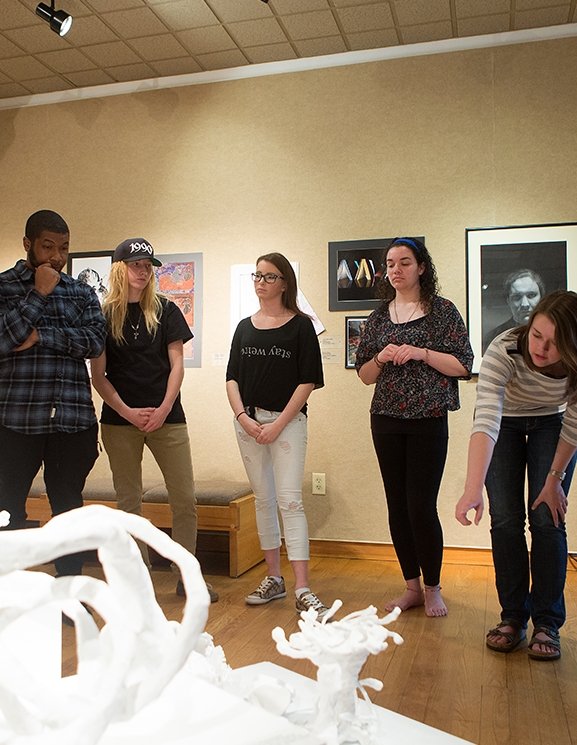 Students critiquing work in the visual arts gallery