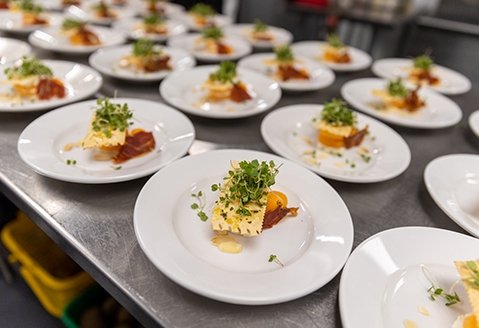 Plates of food being prepared by culinary students