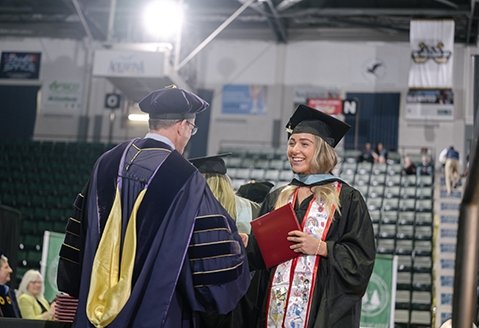 A SUNY Plattsburgh at Queensbury graduate receives her diploma at commencement