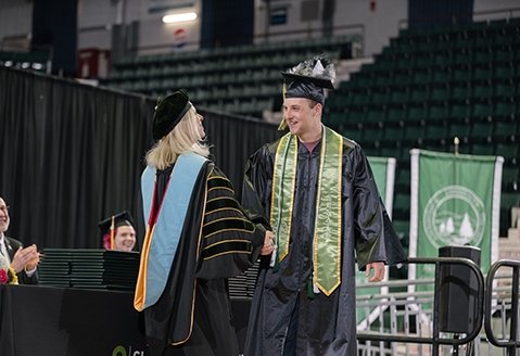 SUNY Adirondack graduate Toby Greer shakes President Duffy's hand at Commencement 2024.