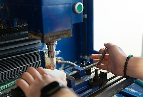 Close-up image of hands working on a machine