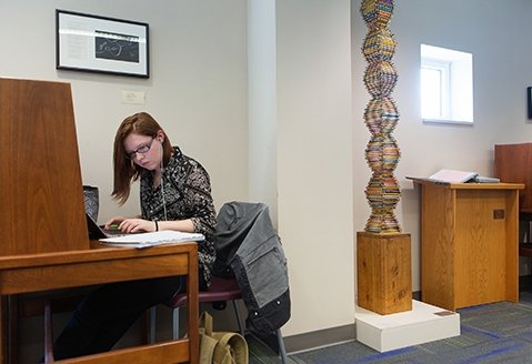 A young woman studies in the library at SUNY Adirondack