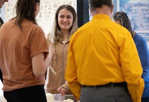 A student discusses with her peers in an archaeology class