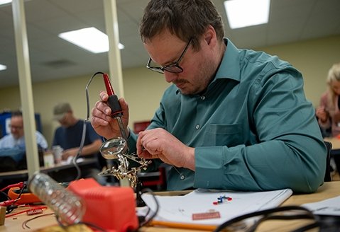 A student leans over his work in an IT boot camp class at SUNY Adirondack Saratoga.