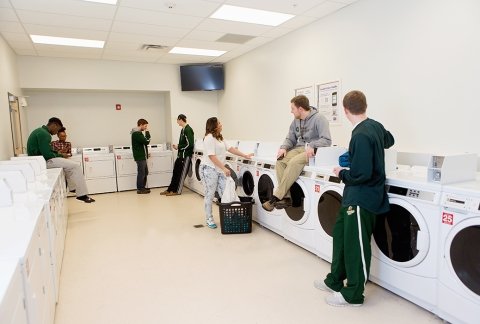 Students visit while doing their laundry in the Residence Hall