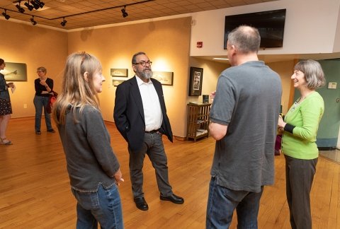 Artist, Alberto Ray, speaking to patrons in the gallery during his exhibition opening