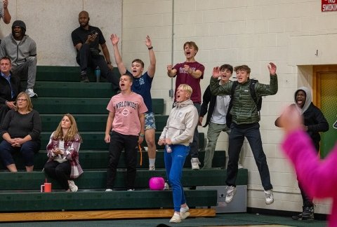 Crowd of students cheering on the volleyball team