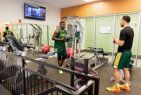 Basketball students workout in the fitness center