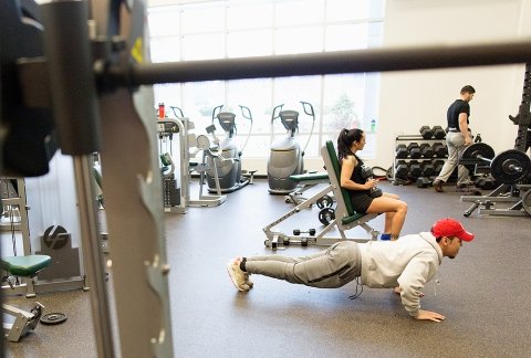Students workout in the fitness center in the residence hall