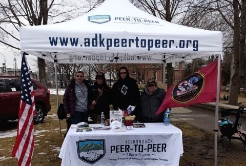 Peer to Peer veterans man a table at the Winter Carnival