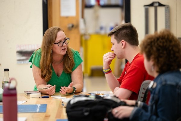 An instructor speaks to students in the library